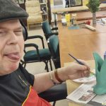 Michael painting a clay vase