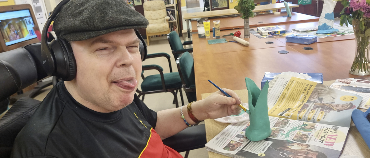 Michael painting a clay vase